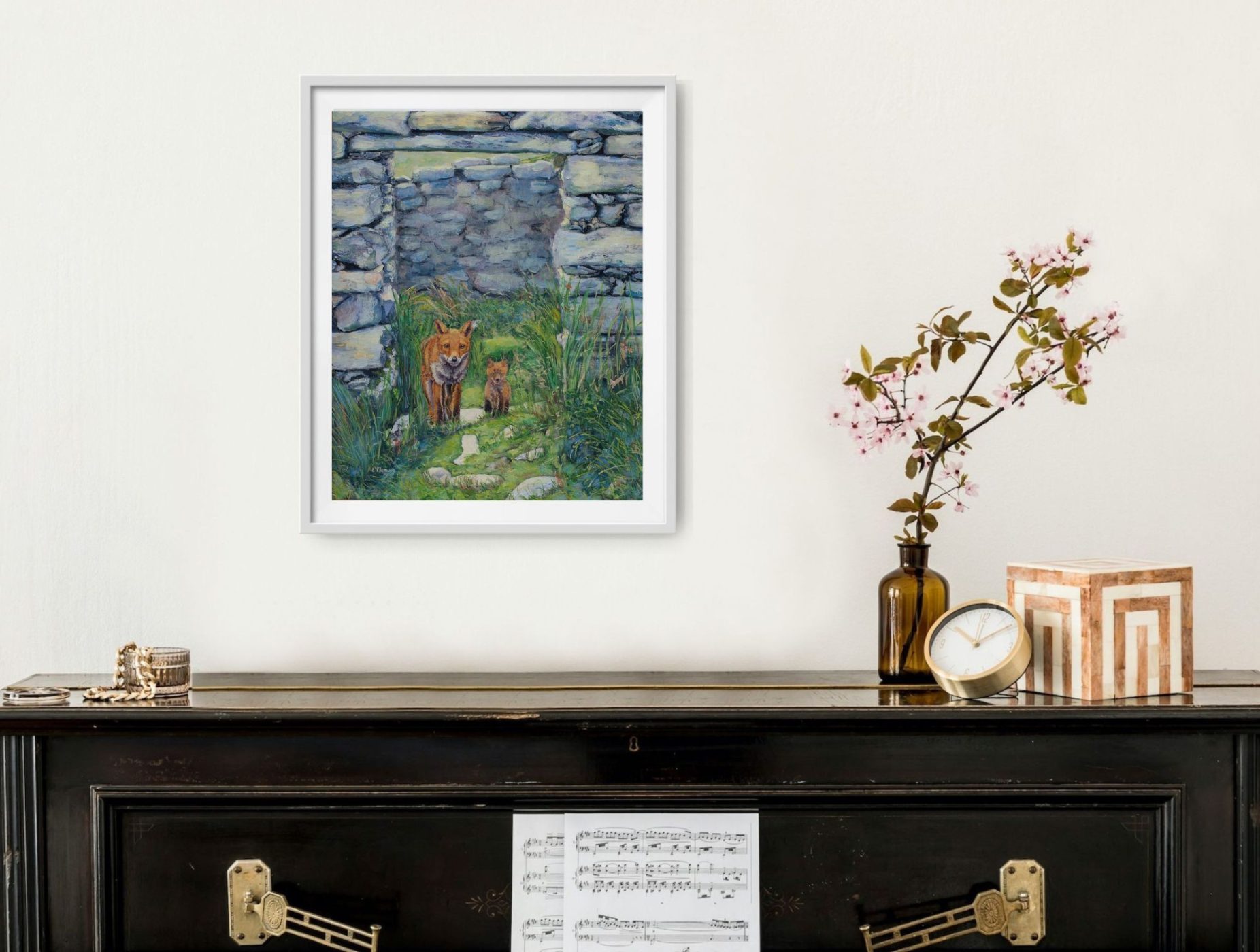 The framed fox painting displayed above a dark mantel.