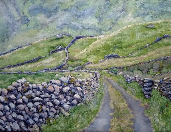 A narrow road running between dry-stone walls into green hills.